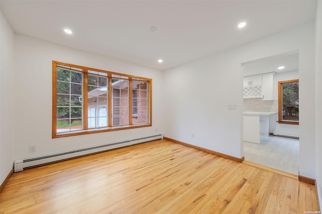 spare room featuring light wood-type flooring and a baseboard radiator