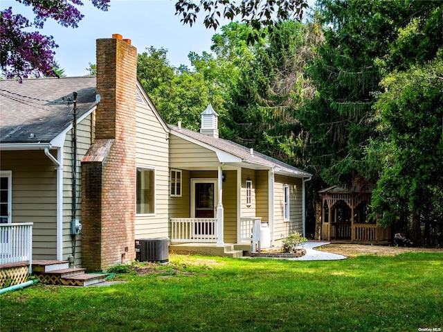 back of property featuring a lawn, a gazebo, and central AC unit