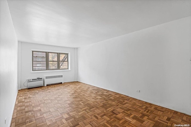 empty room with parquet floors and radiator