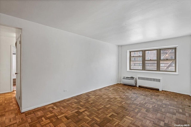 empty room with radiator and dark parquet floors