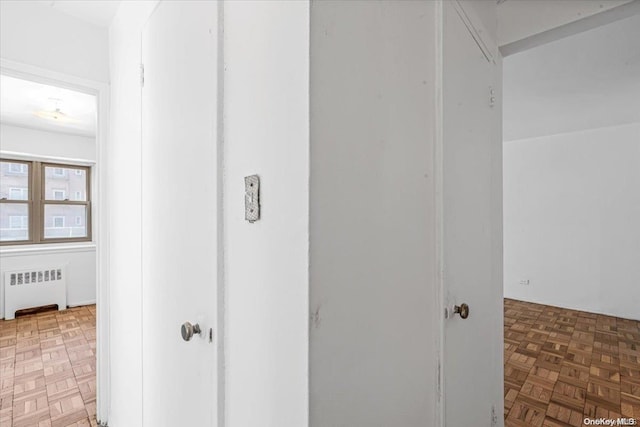 interior space featuring radiator heating unit and parquet flooring