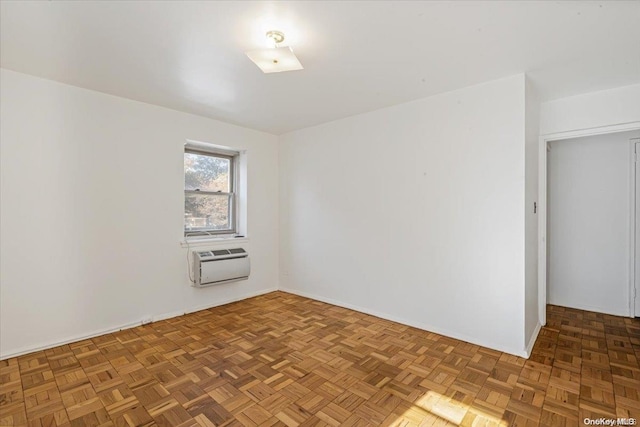 spare room featuring parquet flooring and a wall mounted AC