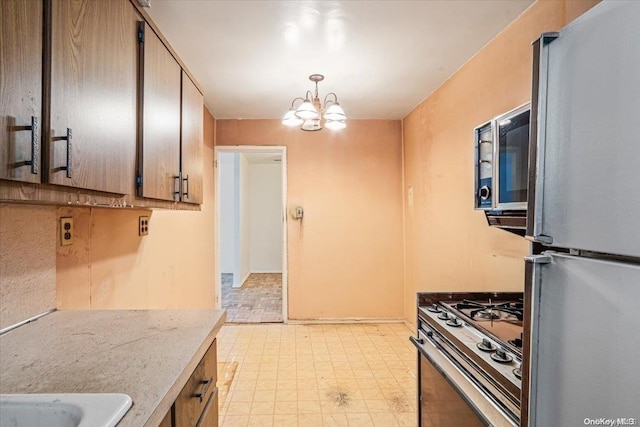 kitchen with decorative light fixtures, appliances with stainless steel finishes, and an inviting chandelier