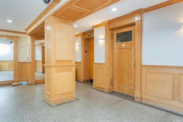 interior space featuring decorative columns, crown molding, and light brown cabinets