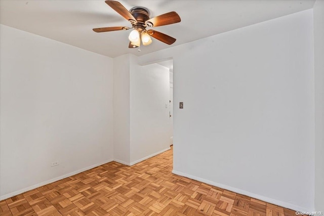 spare room with ceiling fan and light parquet floors