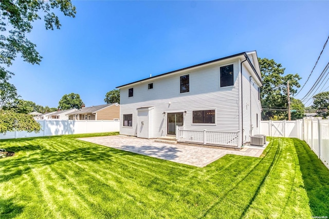 rear view of property featuring central air condition unit, a yard, and a patio