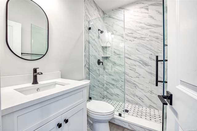 bathroom with a shower with door, vanity, and toilet