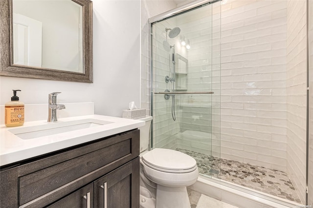 bathroom with tile patterned floors, a shower with door, vanity, and toilet