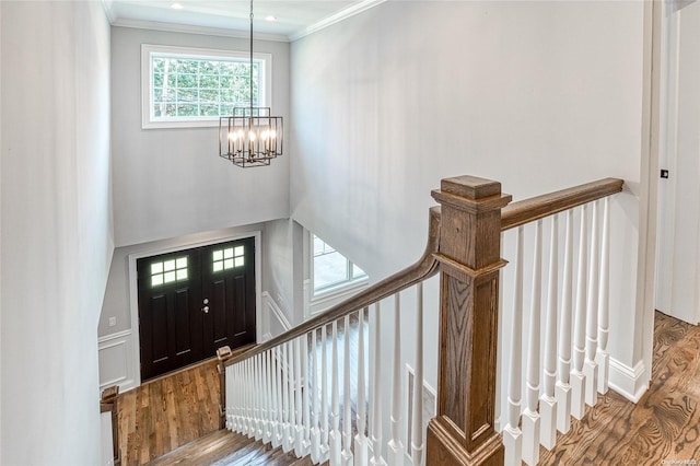 foyer featuring ornamental molding, hardwood / wood-style flooring, and a notable chandelier