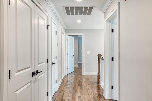 hall with light hardwood / wood-style floors and crown molding