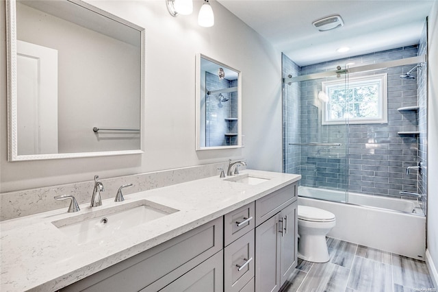 full bathroom featuring toilet, vanity, bath / shower combo with glass door, and wood-type flooring