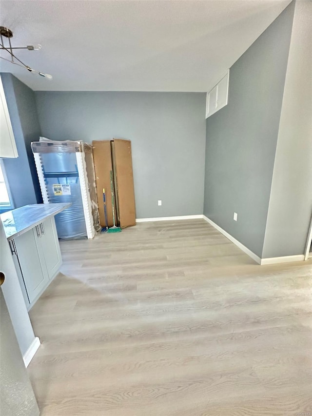 interior space featuring light wood finished floors and baseboards