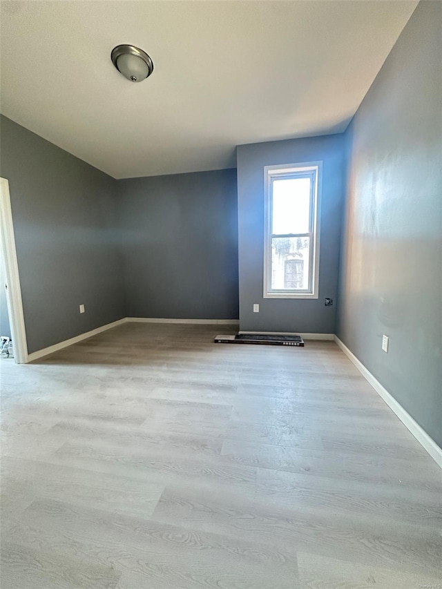 unfurnished room with baseboards and wood finished floors