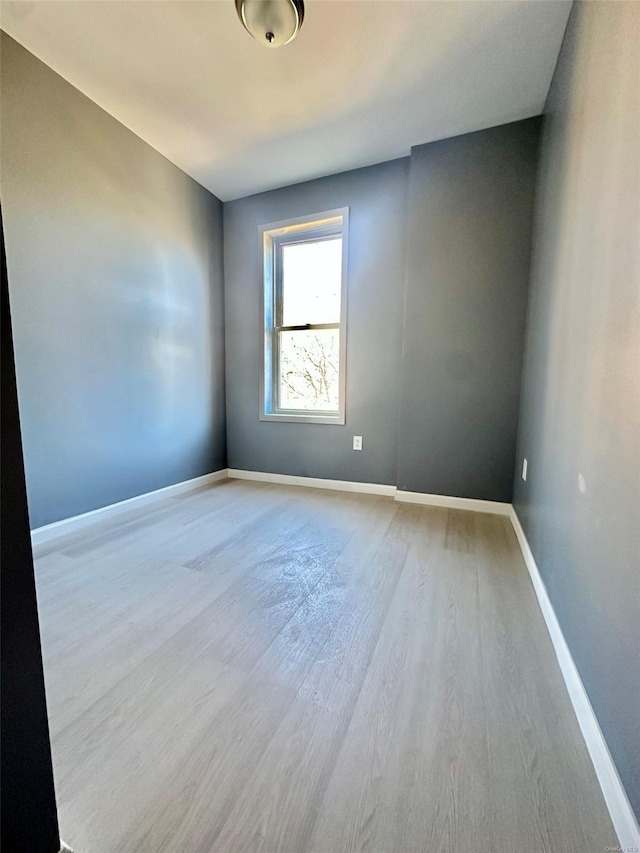 empty room with baseboards and wood finished floors