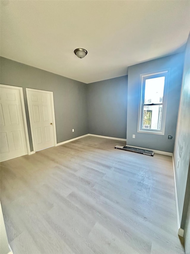 unfurnished bedroom with baseboards and wood finished floors