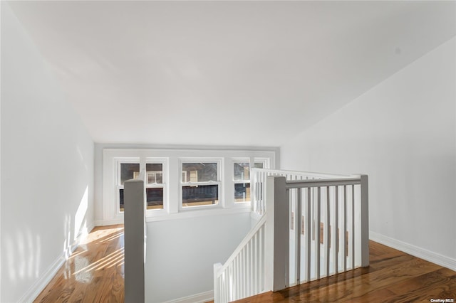 stairs with hardwood / wood-style flooring and vaulted ceiling