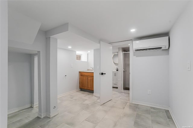 basement with a wall mounted air conditioner and sink