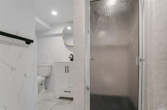 bathroom with vanity, toilet, an enclosed shower, and tile walls