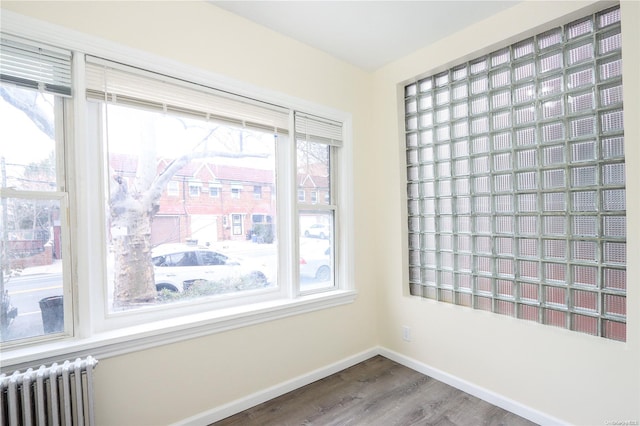 unfurnished room featuring hardwood / wood-style floors and radiator