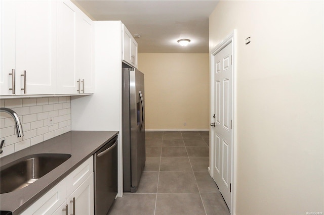 kitchen with decorative backsplash, appliances with stainless steel finishes, white cabinetry, and sink