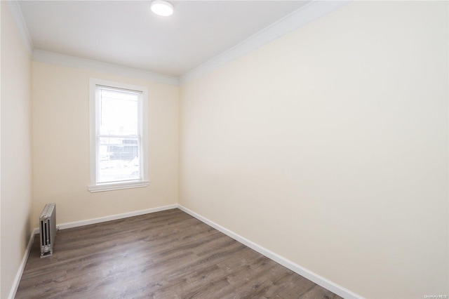 unfurnished room featuring radiator heating unit, dark hardwood / wood-style flooring, and ornamental molding