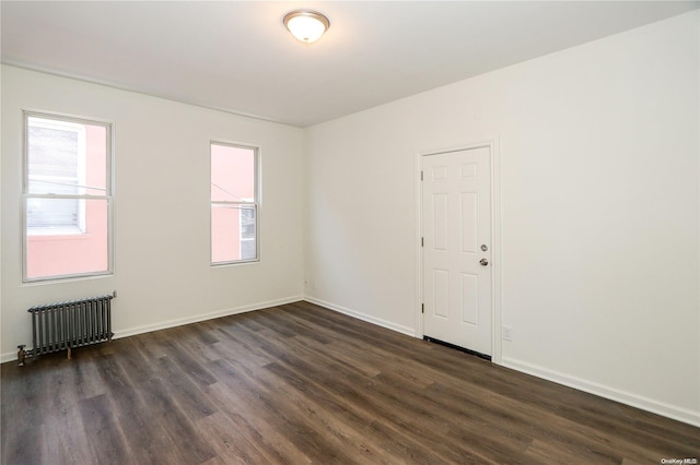 unfurnished room featuring dark hardwood / wood-style floors and radiator