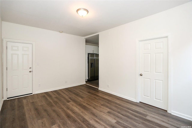 unfurnished room with dark hardwood / wood-style flooring