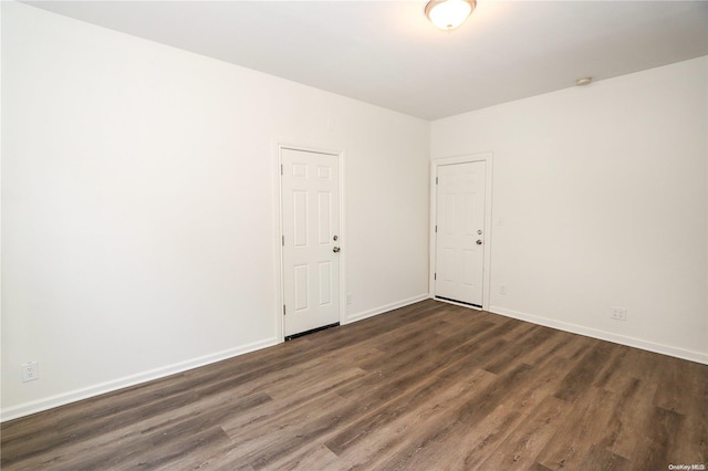 unfurnished room with dark hardwood / wood-style flooring