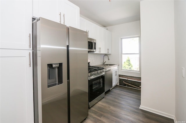 kitchen featuring white cabinets, sink, dark hardwood / wood-style floors, appliances with stainless steel finishes, and tasteful backsplash