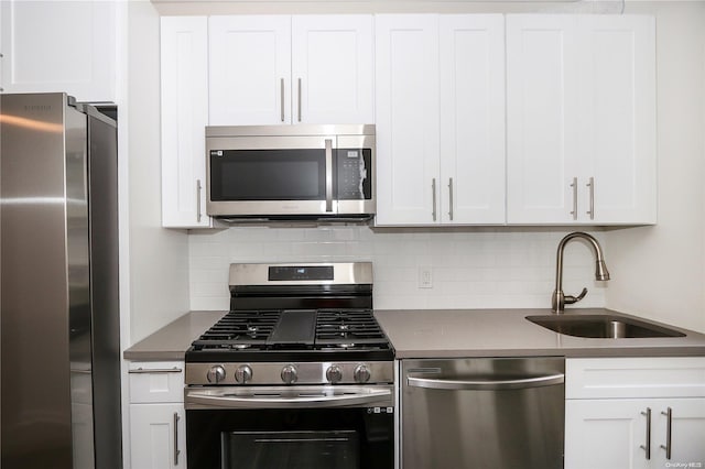 kitchen featuring white cabinets, appliances with stainless steel finishes, backsplash, and sink