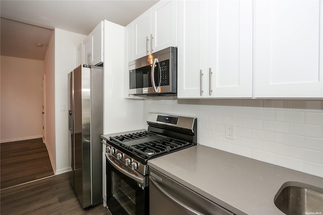 kitchen featuring decorative backsplash, white cabinetry, dark hardwood / wood-style flooring, and appliances with stainless steel finishes