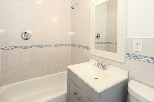 full bathroom featuring vanity, toilet, tile walls, and tiled shower / bath