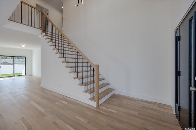 staircase featuring hardwood / wood-style flooring and a high ceiling