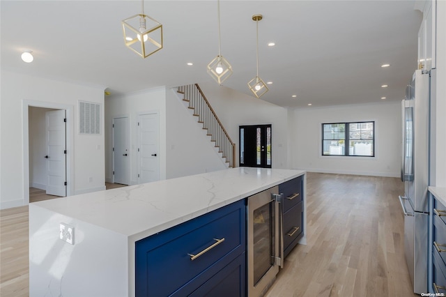 kitchen with stainless steel fridge, beverage cooler, decorative light fixtures, a center island, and light hardwood / wood-style floors