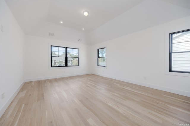 empty room with vaulted ceiling and light wood-type flooring