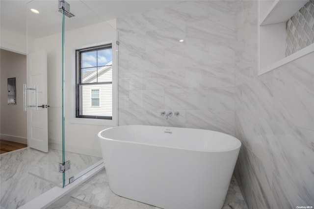 bathroom with electric panel, a washtub, and tile walls