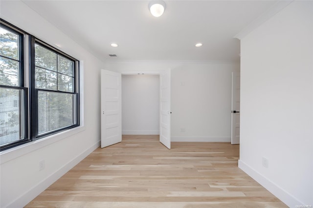 unfurnished bedroom with crown molding and light hardwood / wood-style floors