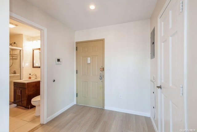 entryway featuring electric panel, sink, and light hardwood / wood-style floors