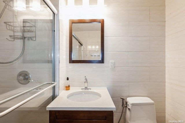 bathroom featuring toilet, vanity, tile walls, and walk in shower