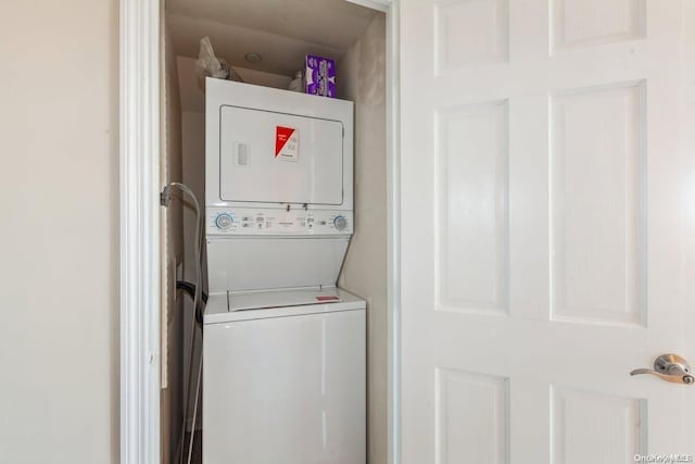 clothes washing area featuring stacked washer / drying machine