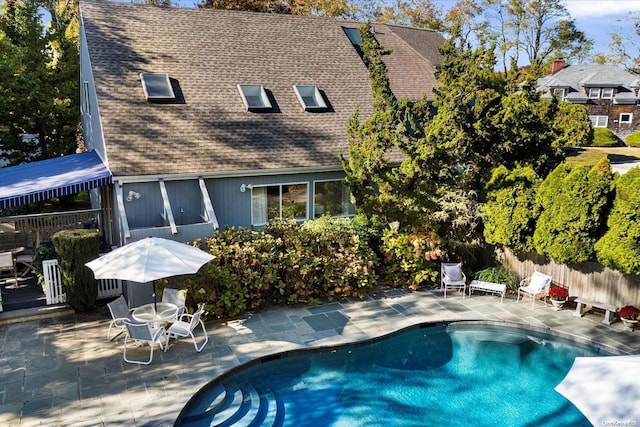 back of property featuring a fenced in pool and a patio