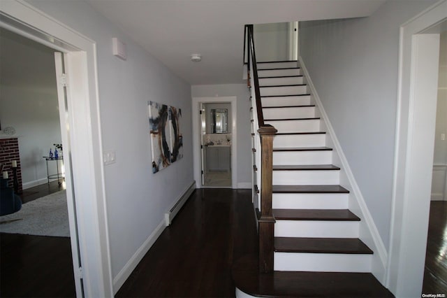 stairs featuring hardwood / wood-style floors and a baseboard heating unit