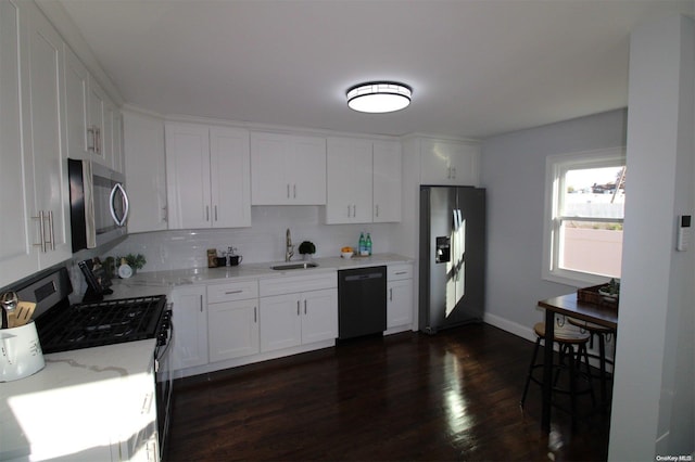 kitchen with decorative backsplash, dark hardwood / wood-style flooring, sink, black appliances, and white cabinetry