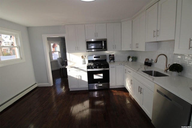 kitchen featuring sink, dark hardwood / wood-style floors, decorative backsplash, appliances with stainless steel finishes, and white cabinetry