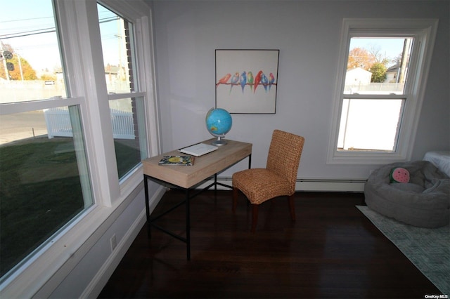 office featuring a wealth of natural light, dark wood-type flooring, and a baseboard heating unit