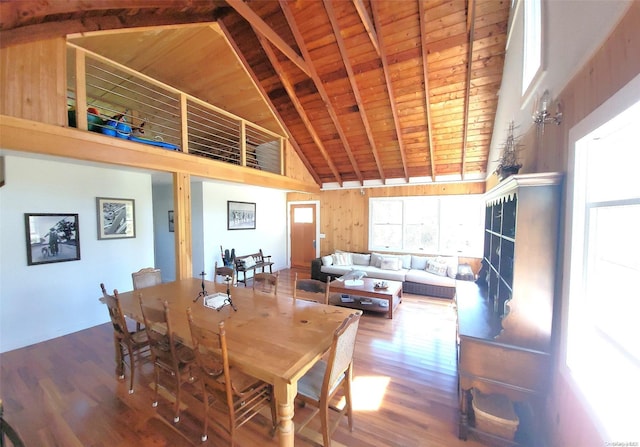 dining area featuring beam ceiling, hardwood / wood-style flooring, high vaulted ceiling, and wooden ceiling