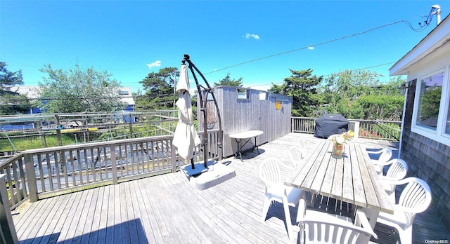 wooden deck featuring a water view and grilling area