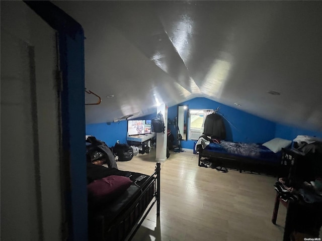 bedroom featuring lofted ceiling and light wood-type flooring