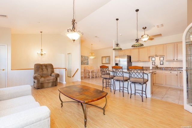 living room featuring light hardwood / wood-style floors, ceiling fan, and lofted ceiling