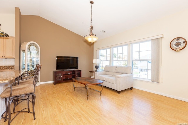 living room with light wood-type flooring and vaulted ceiling